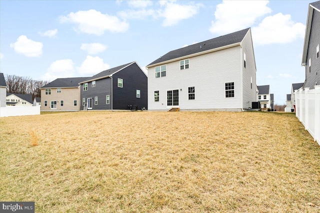 back of property with cooling unit, a yard, a residential view, and fence