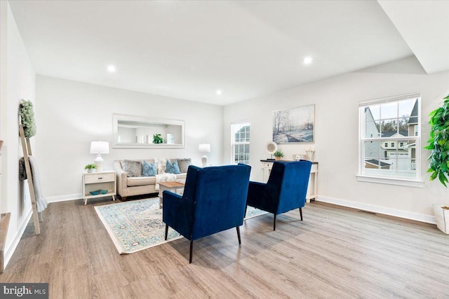 living area with a healthy amount of sunlight, light wood-style flooring, baseboards, and recessed lighting