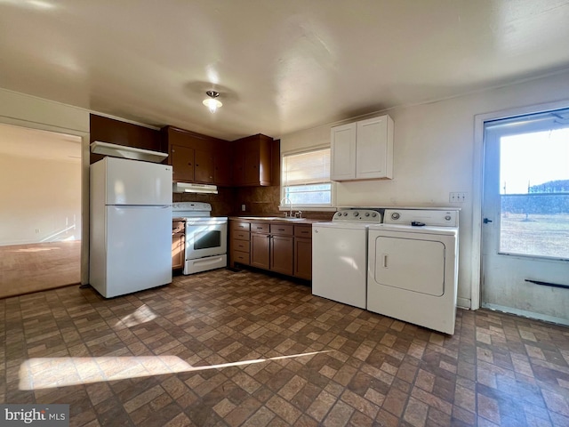 kitchen featuring white appliances, sink, and washing machine and dryer