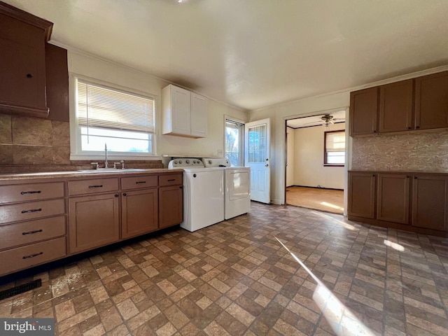 kitchen with tasteful backsplash, sink, washing machine and clothes dryer, and ceiling fan