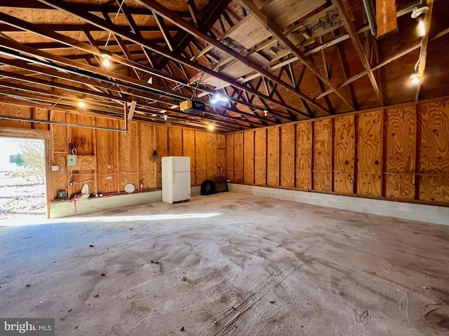 garage with white refrigerator and a garage door opener