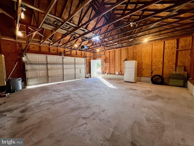 garage with white refrigerator and a garage door opener