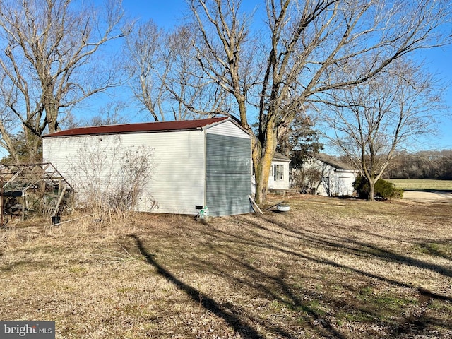 view of home's exterior with a yard and an outdoor structure