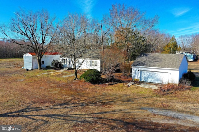 view of front of home with a garage and an outdoor structure