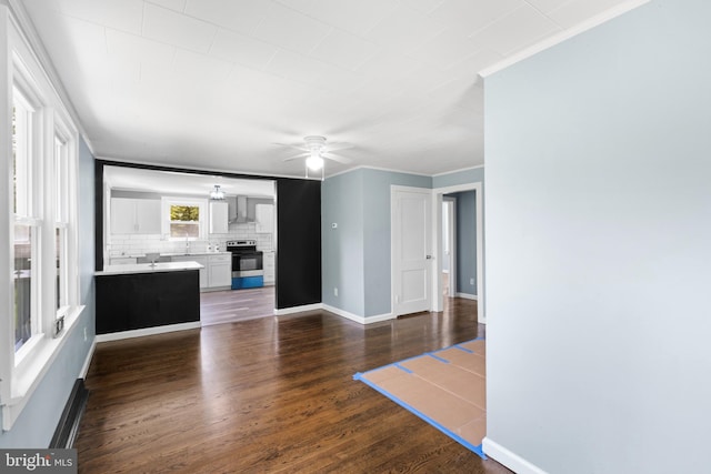 unfurnished living room with ceiling fan, ornamental molding, and dark hardwood / wood-style flooring