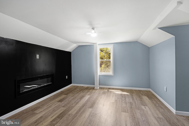 additional living space featuring vaulted ceiling, light hardwood / wood-style floors, and ceiling fan