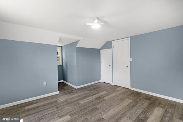 additional living space featuring vaulted ceiling and dark hardwood / wood-style floors