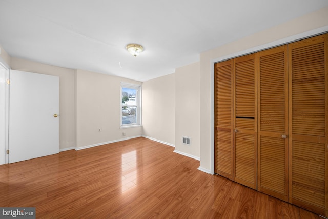 unfurnished bedroom featuring light hardwood / wood-style floors and a closet