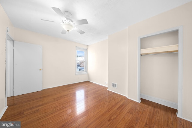 unfurnished bedroom featuring ceiling fan, wood-type flooring, and a closet