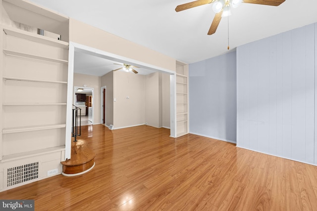 unfurnished living room featuring hardwood / wood-style flooring, built in features, and ceiling fan