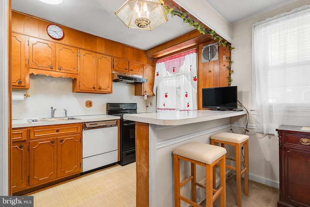 kitchen featuring pendant lighting, sink, a breakfast bar, white dishwasher, and gas stove