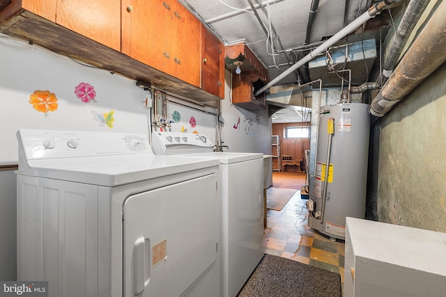 clothes washing area with separate washer and dryer, gas water heater, and cabinets