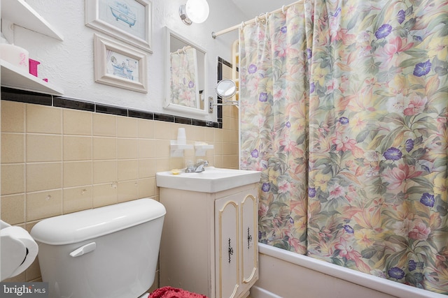 full bathroom featuring shower / tub combo with curtain, vanity, toilet, and tile walls