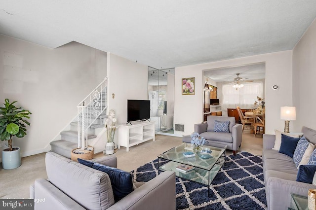 carpeted living room with ceiling fan