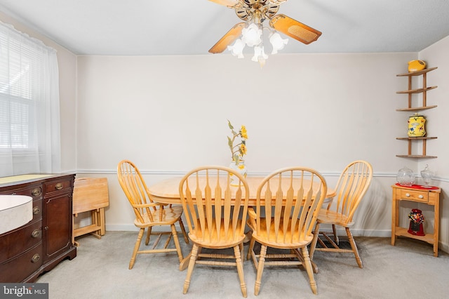 dining room with ceiling fan and light colored carpet