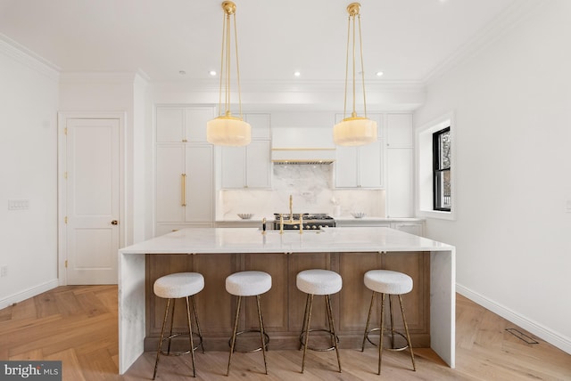 kitchen featuring a spacious island, white cabinets, ornamental molding, and decorative backsplash