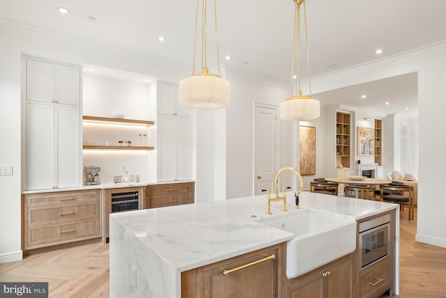 kitchen with wine cooler, open shelves, ornamental molding, a sink, and built in microwave