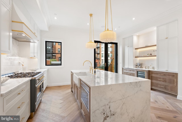 kitchen with beverage cooler, stainless steel appliances, a sink, open shelves, and crown molding