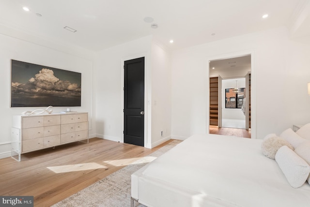 bedroom featuring light wood-style floors, recessed lighting, ornamental molding, and baseboards