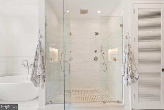 full bath with recessed lighting, a soaking tub, and a shower stall