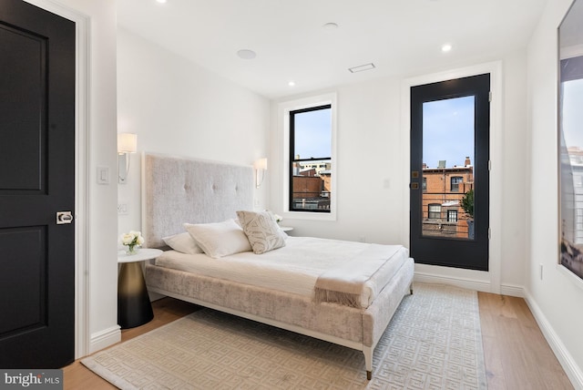 bedroom with light wood finished floors, recessed lighting, and baseboards