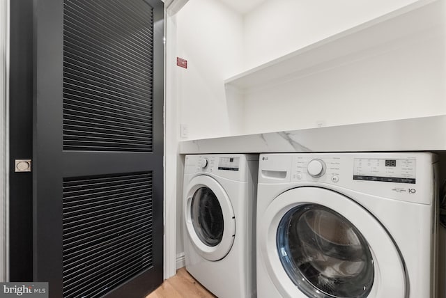 laundry room featuring light wood-style flooring and washer and dryer