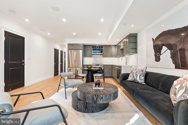 living area featuring recessed lighting, crown molding, light wood-style flooring, and baseboards