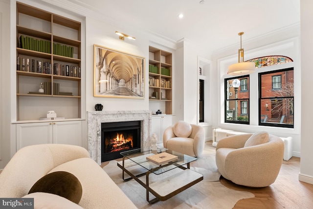 living area featuring recessed lighting, a fireplace, baseboards, built in features, and ornamental molding