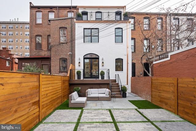 rear view of property with a patio area, a fenced backyard, outdoor lounge area, and brick siding