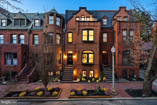 townhome / multi-family property featuring brick siding and stairway