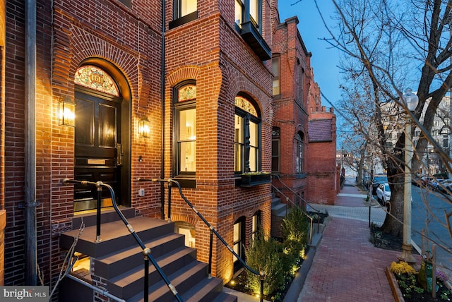 view of exterior entry featuring brick siding