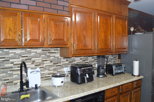 kitchen with sink, backsplash, stainless steel refrigerator, and black dishwasher