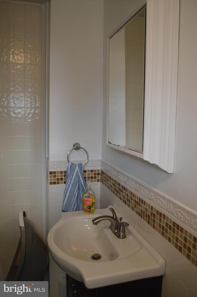 bathroom with sink and tile walls