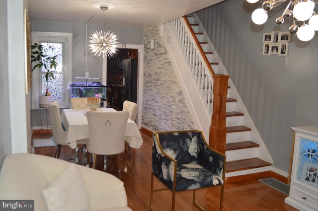 dining room with dark hardwood / wood-style flooring and a chandelier