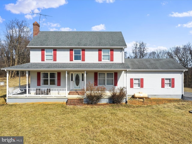 view of front of property featuring covered porch, roof with shingles, a chimney, and a front yard