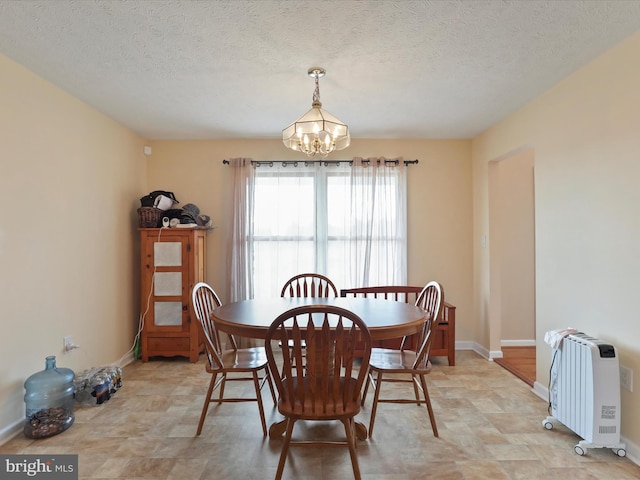 dining room featuring radiator, an inviting chandelier, baseboards, and a textured ceiling