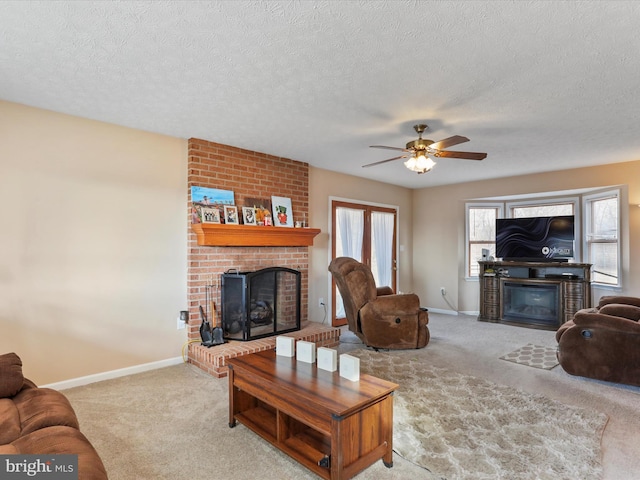 carpeted living room with a textured ceiling, a fireplace, a ceiling fan, and baseboards