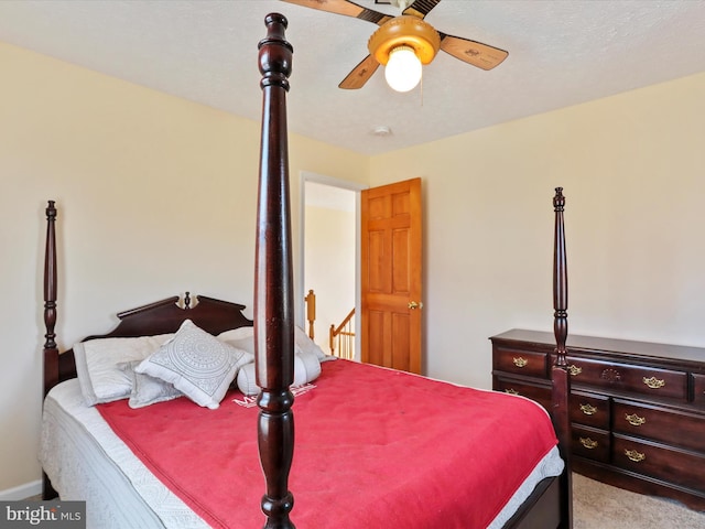 carpeted bedroom with ceiling fan and a textured ceiling