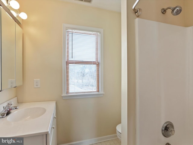 bathroom with toilet, visible vents, vanity, baseboards, and tub / shower combination