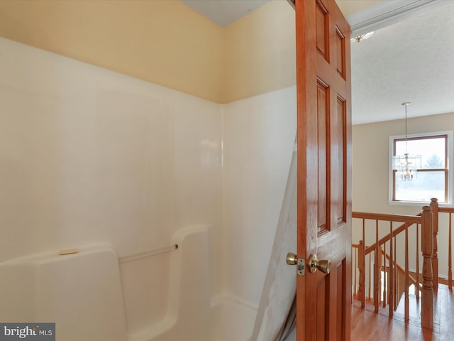 bathroom featuring a notable chandelier and wood finished floors