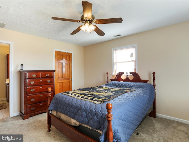 bedroom with light carpet, a textured ceiling, visible vents, and baseboards