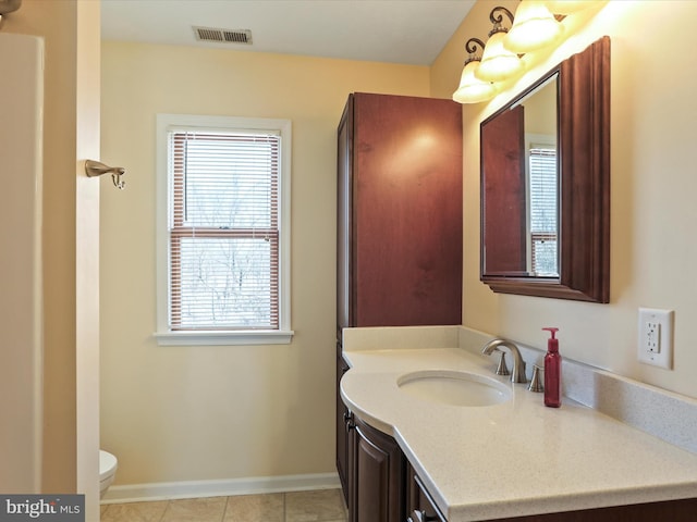 bathroom featuring visible vents, toilet, vanity, tile patterned flooring, and baseboards