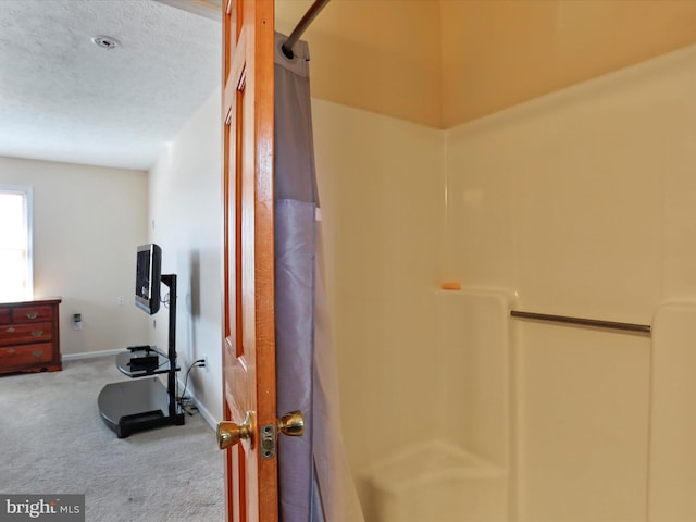 interior space with a textured ceiling, carpet flooring, and baseboards