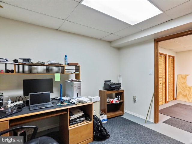 home office with a paneled ceiling and baseboards