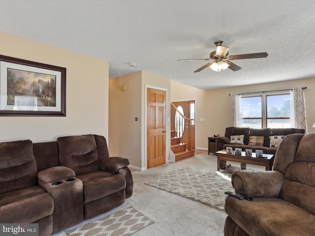 living room featuring stairway, a ceiling fan, light carpet, a textured ceiling, and baseboards