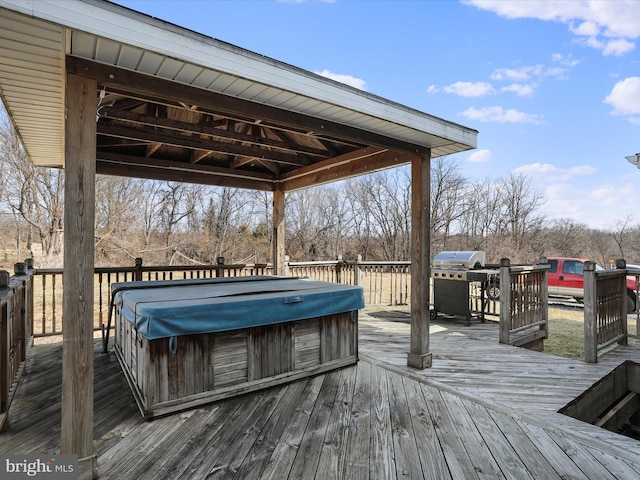 deck with a grill, a hot tub, and a gazebo