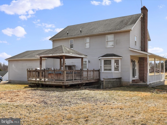 back of house featuring a wooden deck, a chimney, a shingled roof, and a gazebo