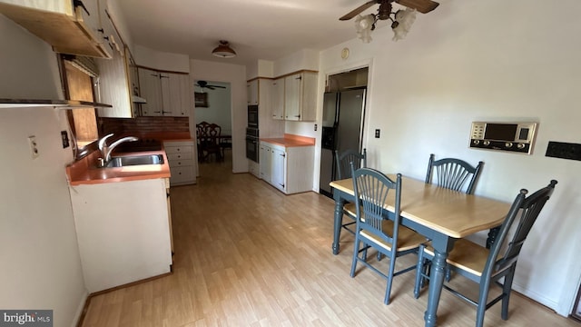 dining space featuring light wood-style flooring and ceiling fan