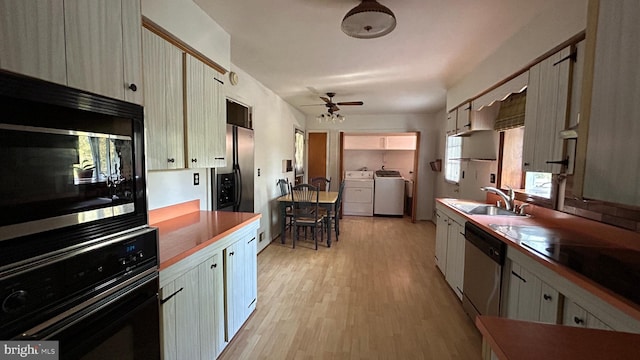 kitchen with light wood-style flooring, a sink, separate washer and dryer, ceiling fan, and black appliances