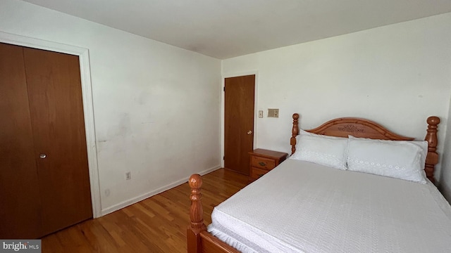 bedroom with wood finished floors and baseboards
